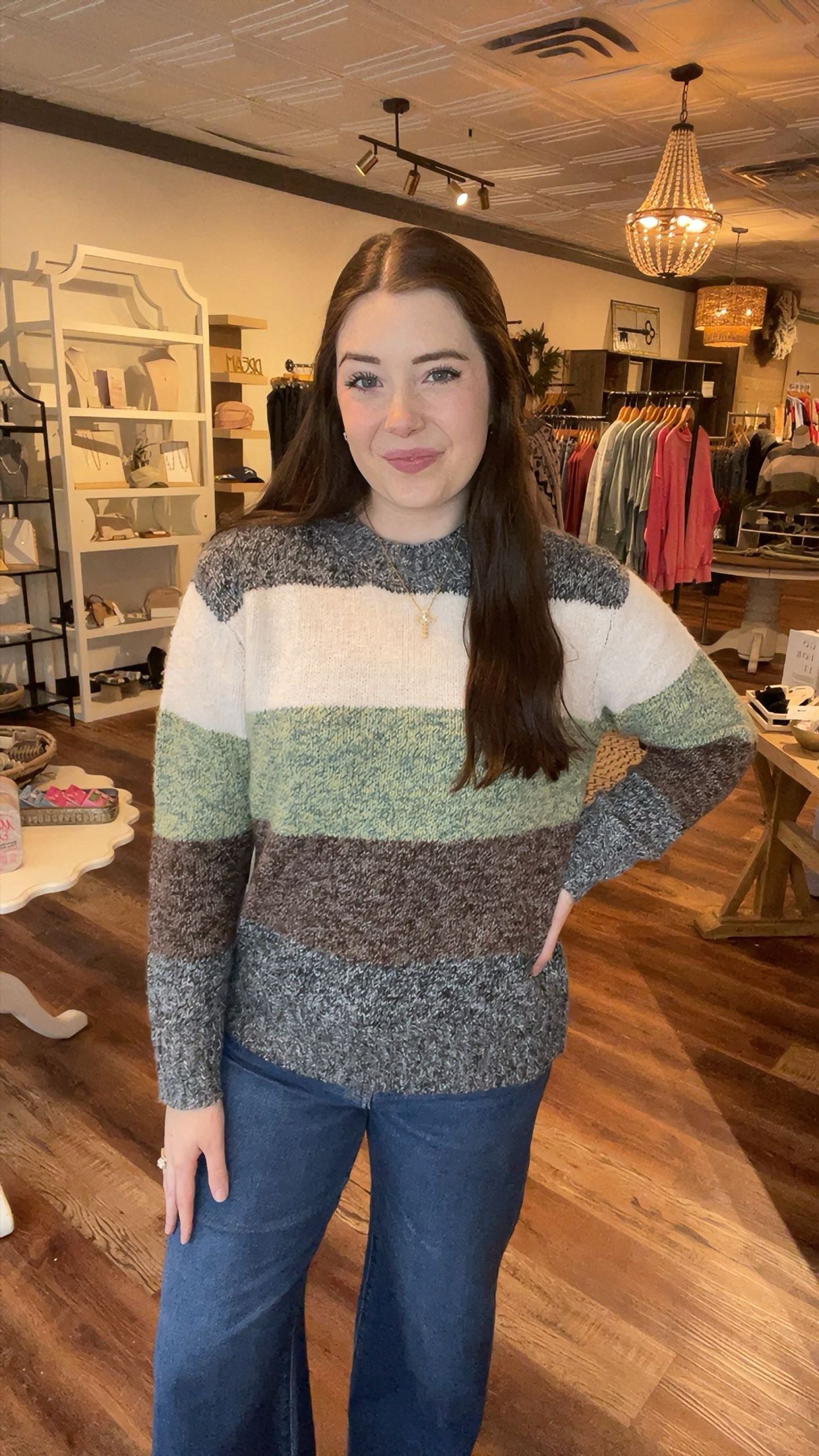 Woman wearing a striped sweater and jeans in a store setting