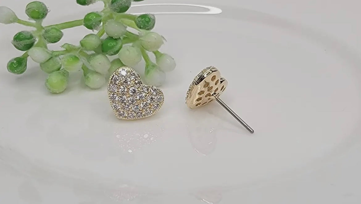 Heart-shaped earrings with sparkling details on a light background