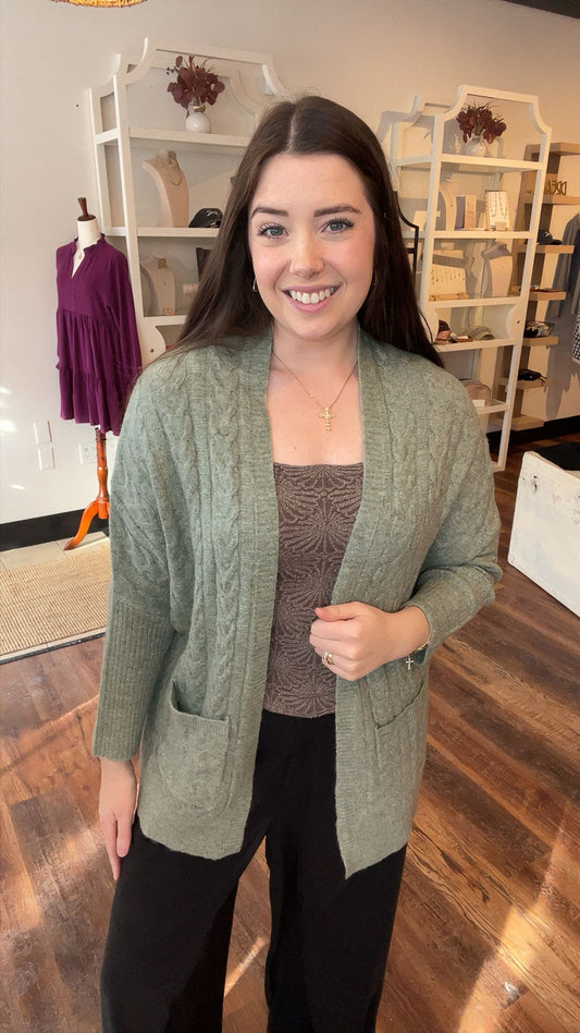 Woman wearing a green cardigan in a store setting
